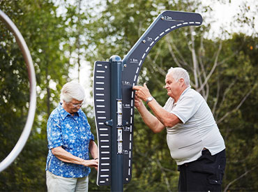 twee ouderen aan het sporten op een sportschool in de buitenlucht